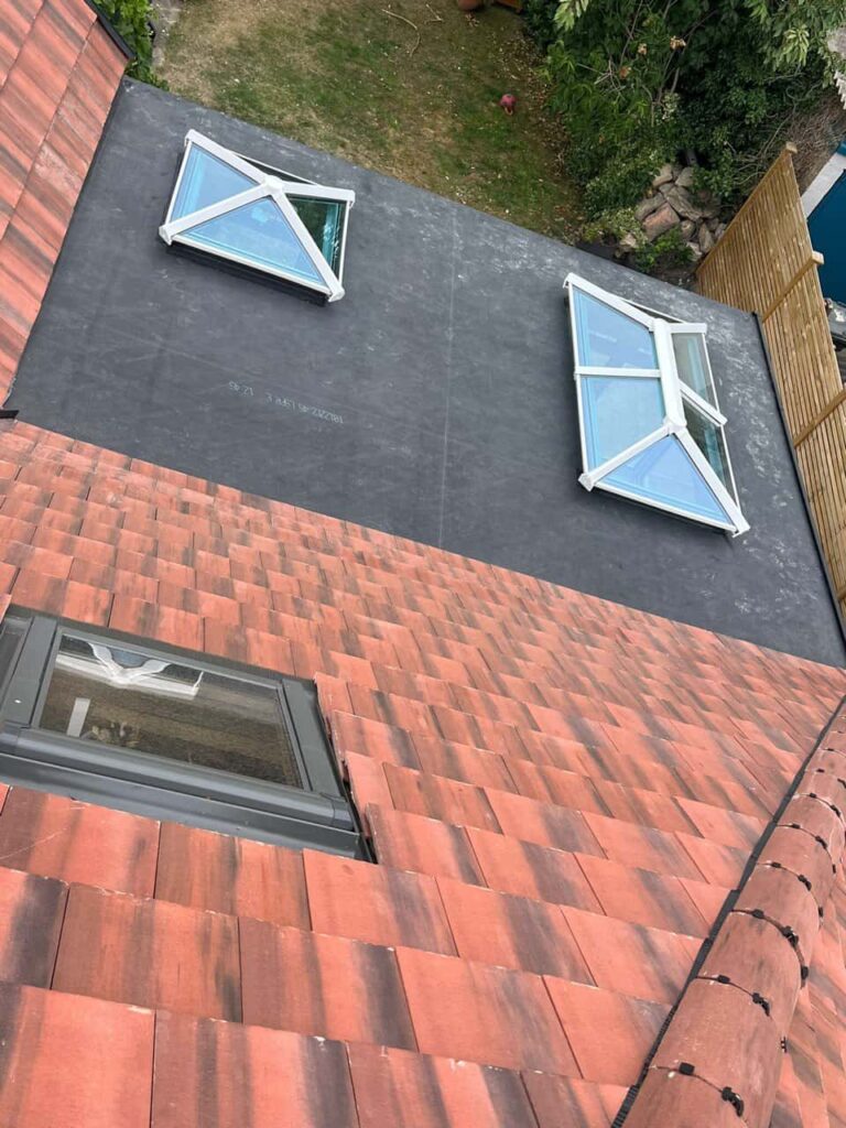 This is a photo taken from the roof ridge looking down a tiled pitched roof on to a flat roof. Works carried out by Histon Roofing Repairs